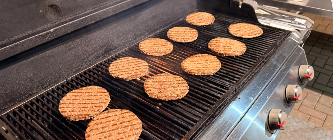 Patties auf dem Grill vor dem Laden