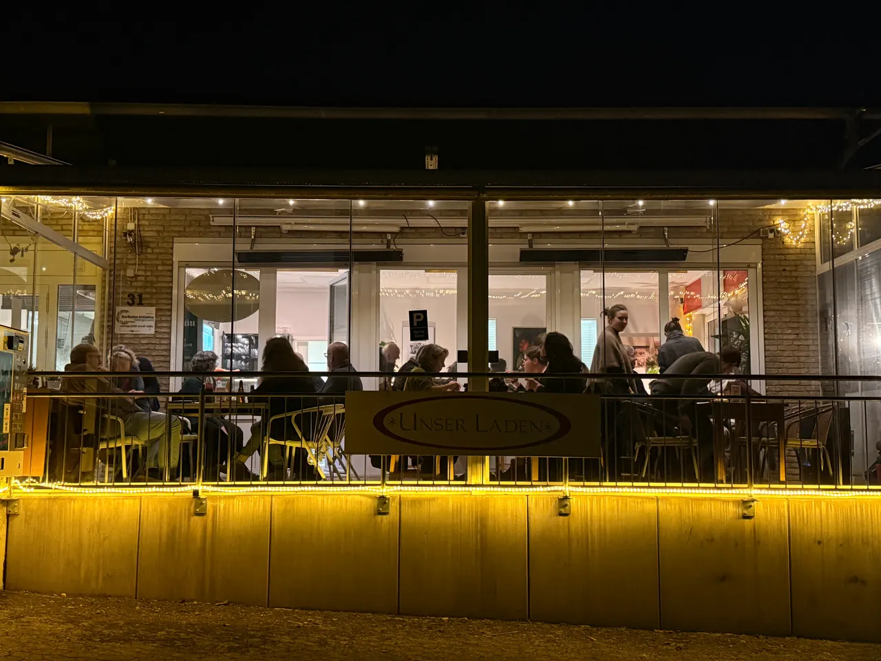 Das Berg-Café am Freitagabend von außen, warm erleuchtet und voll besetzt
