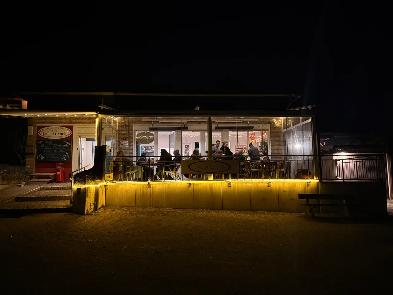 Das voll besetzte Berg-Café bei Nacht, warm erleuchtet