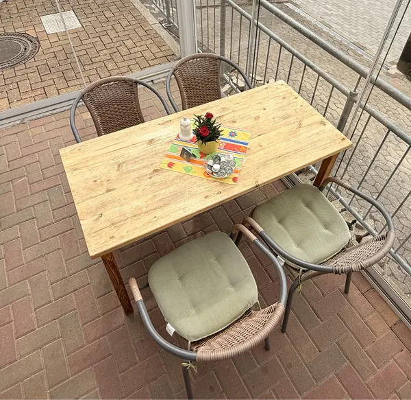 Gedeckter Terrassentisch mit Backsteinboden und Geländer